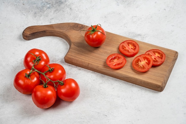 Pomodori rossi freschi su un tagliere di legno