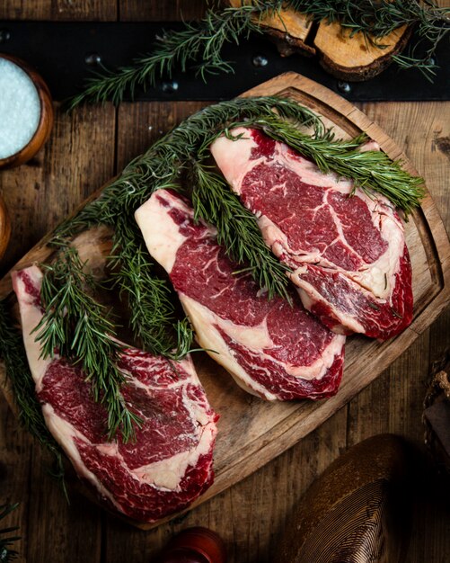 Fresh rib eye steaks on wooden board