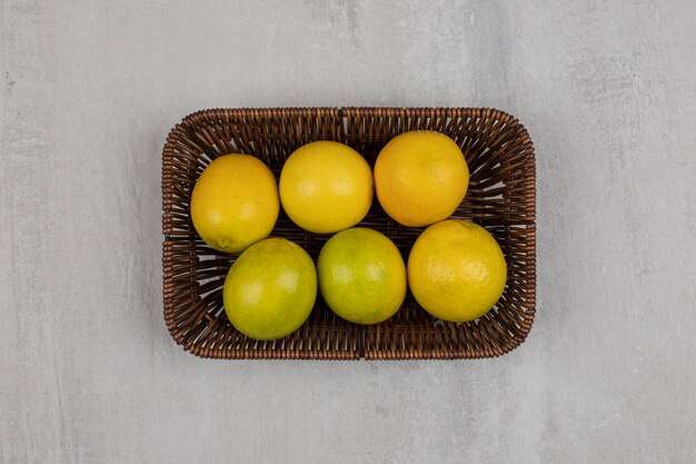 Fresh ripe lemons on wooden basket.