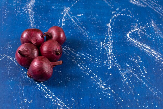 Fresh ripe red onions placed on marble surface