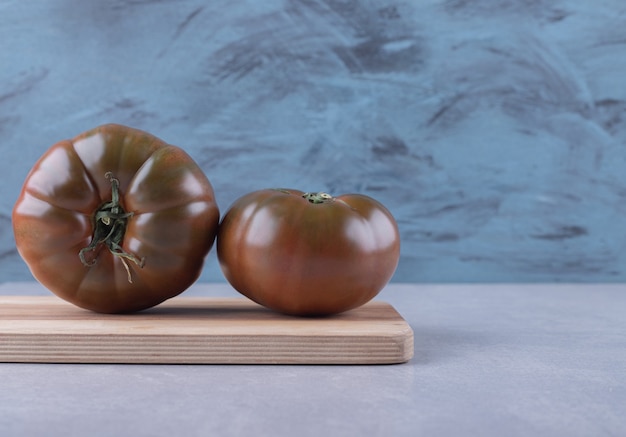 Fresh ripe tomatoes on wooden board. 