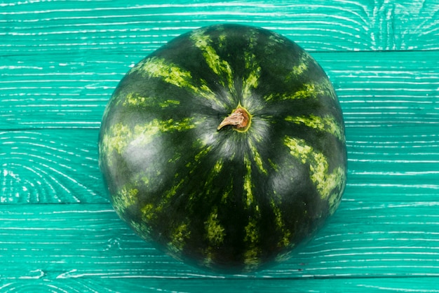 Fresh ripe whole watermelon on green background