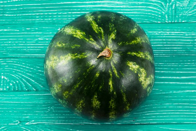 Fresh ripe whole watermelon on green background