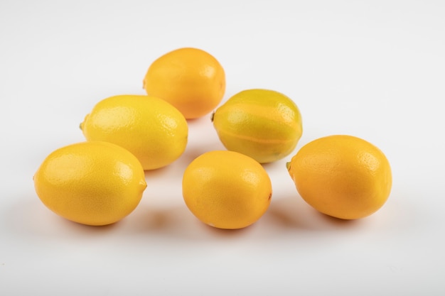 Fresh ripe yellow lemons on white table. 