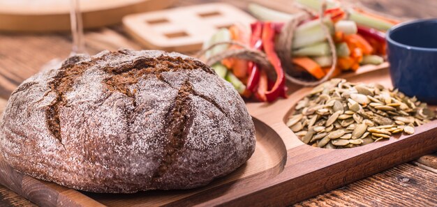 fresh round of dark bread on a wooden plate