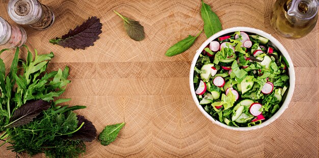 Fresh salad of cucumbers, radishes and herbs. Flat lay. Top view