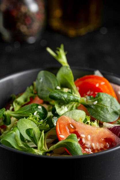 Fresh salad in dark bowl close-up