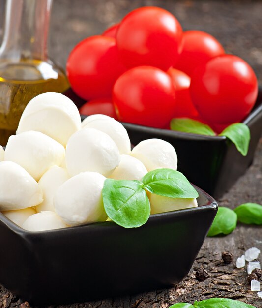 Бесплатное фото Свежий салат с помидорами черри, базиликом, моцареллой и маслинами.