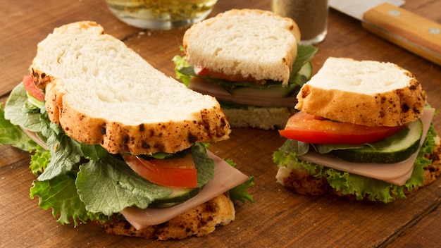 Fresh sandwich with salami and vegetables on table