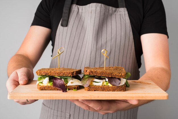 Fresh sandwiches on wooden board