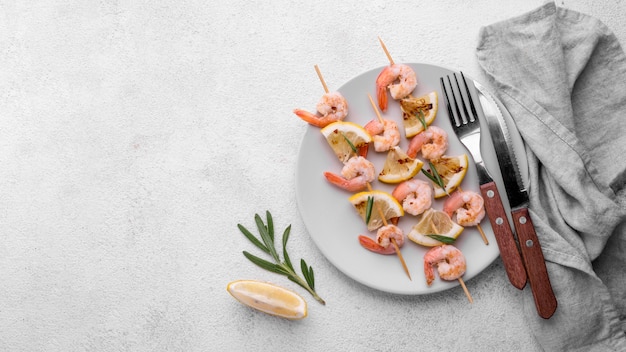 Free photo fresh seafood shrimp skewers and cutlery