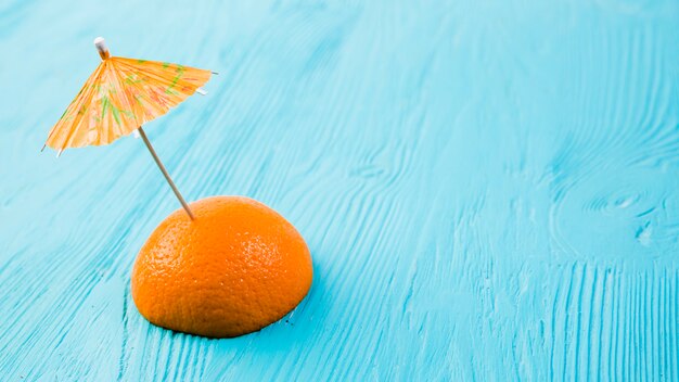 Fresh slice of orange with decorative umbrella