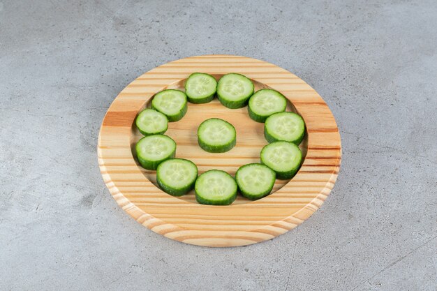 Free photo fresh sliced cucumbers with knife on a wooden board . high quality photo