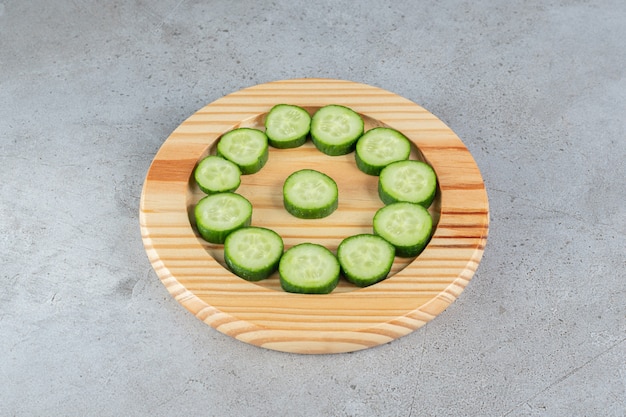 Fresh sliced cucumbers with knife on a wooden board . High quality photo