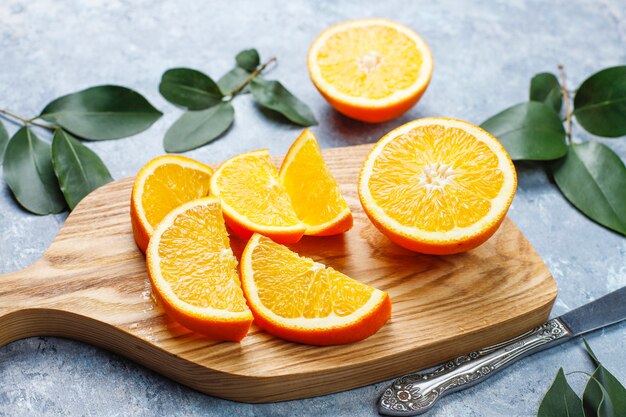 fresh sliced oranges on cutting board on concrete surface 