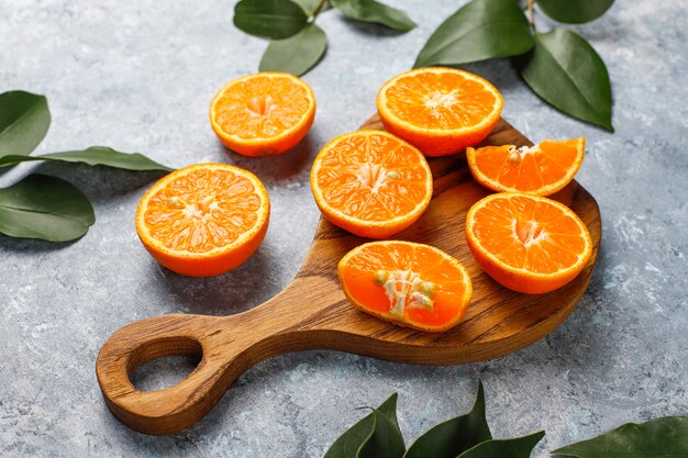 fresh sliced oranges on cutting board on concrete surface 