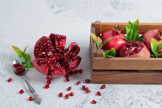 Fresh sliced pomegranate on grey surface with fruit bow. 