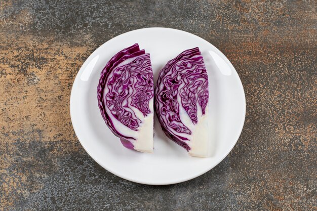 Fresh sliced red cabbage in the plate on the marble surface