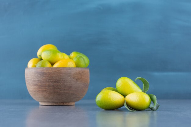 Fresh small tangerines in wooden bowl.