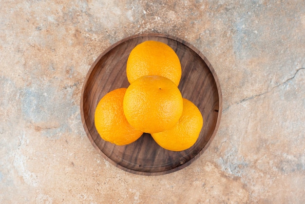 Free photo fresh sour oranges on wooden plate