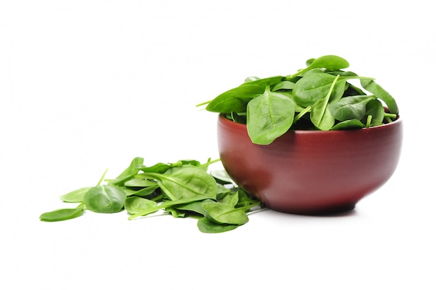 Fresh spinach leaves in bowl isolated