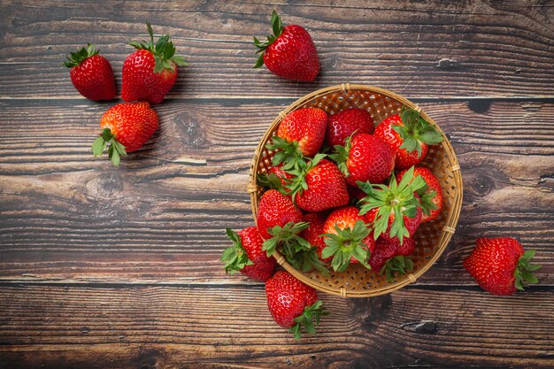 Fresh strawberries in a bowl on wooden table