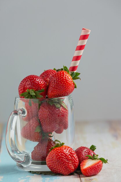 Fresh strawberries in glass on wooden table