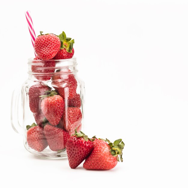 Fresh strawberries in jar on white background