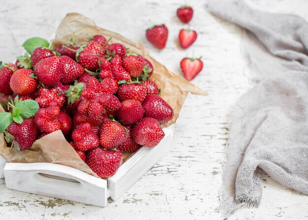 Free photo fresh strawberries on a wooden tray