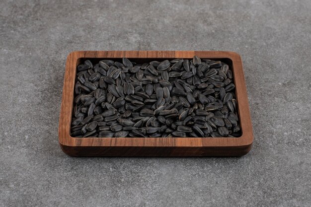 Fresh sunflower seeds in wooden bowl.