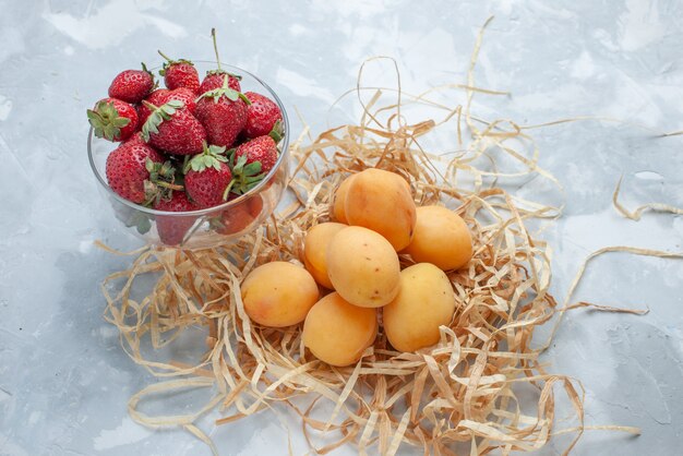 fresh sweet apricots mellow fruits with red strawberries on white