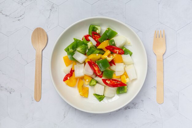 Fresh sweet bell pepper and onion sliced on white plate