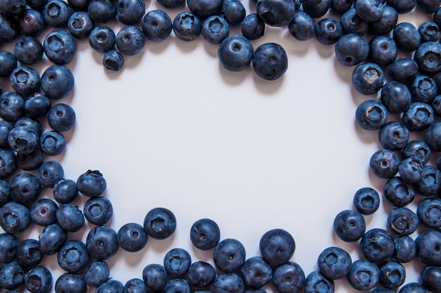 Fresh sweet blueberry fruit and mint leaf with copy space. Dessert healthy food. Group of ripe blue juicy organic berries. For web site, banner design. Isolated on white background.