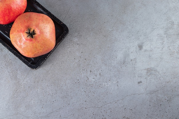 Fresh sweet pomegranates on stone table.