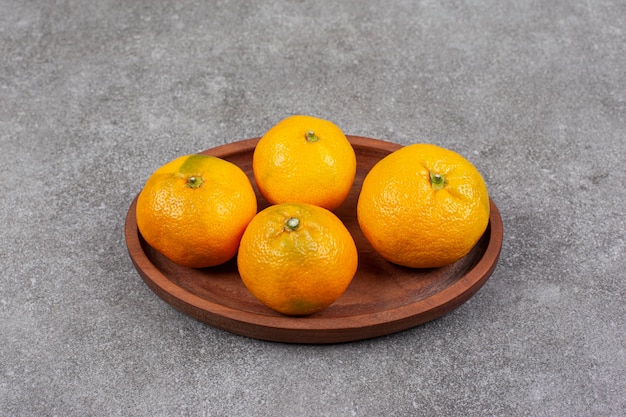 Fresh sweet tangerines on a wooden kitchen board