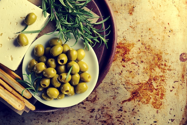 Свежие вкусные греческие зеленые оливки с сыром фета или козьим сыром. Крупный план. Средиземноморская кухня. Тонировка.