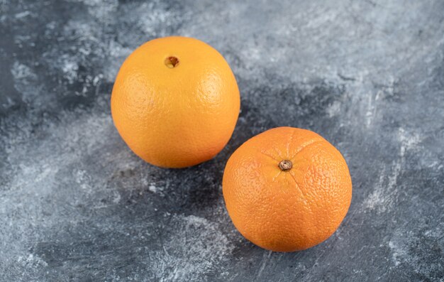 Fresh tasty oranges on marble table.