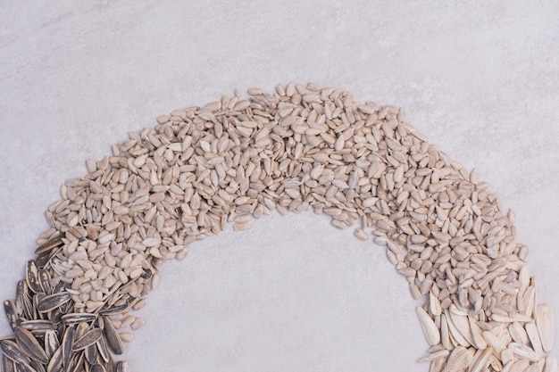 Fresh, tasty sunflower seeds on white table