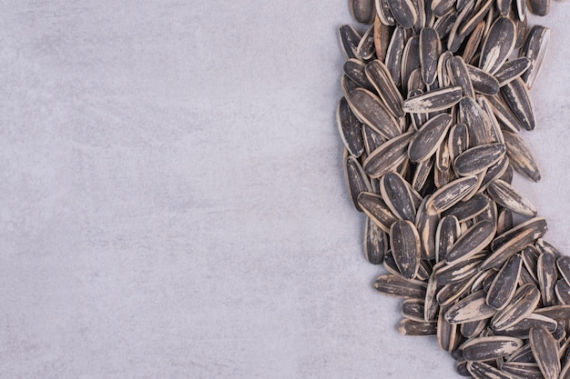 Fresh, tasty sunflower seeds on white table