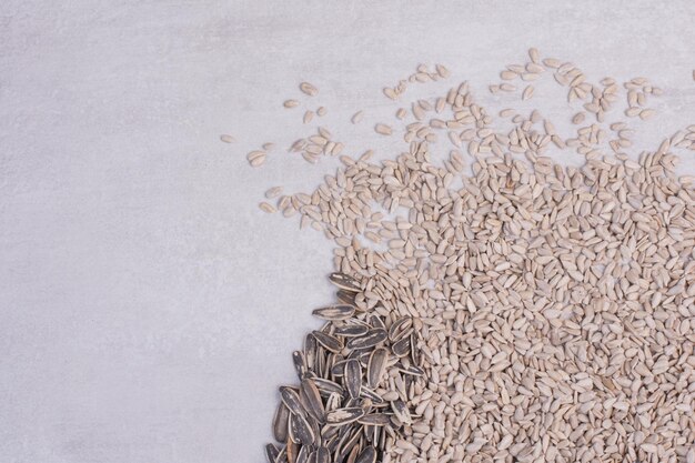 Fresh, tasty sunflower seeds on white table