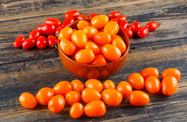 Fresh tomatoes in a bowl high angle view on a wooden table