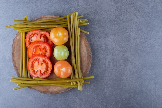 Pomodori freschi, verdi e rossi su tavola di legno.