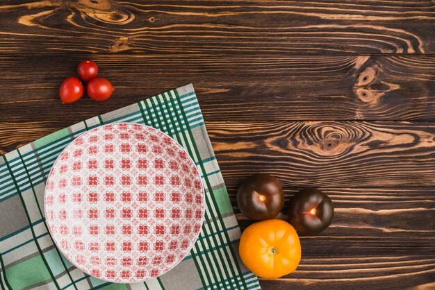 Fresh tomatoes lying near bowl