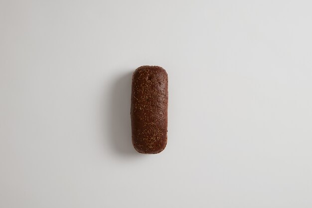 Fresh traditional whole dark loaf of rye bread with cumin isolated on white surface. Whole grain healthy meal. Eating organic products. Selective focus. Shot from above. Food and bakery concept