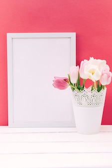 空白​の​フォト​フレーム​と​花瓶​に​新鮮な​チューリップ​の​花