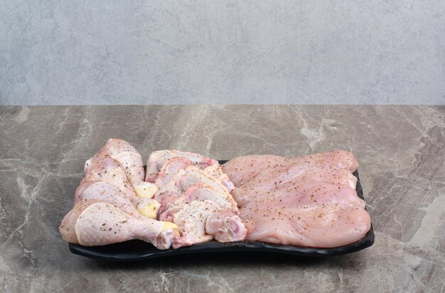 暗いプレートに新鮮な準備されていない鶏の脚。高品質の写真