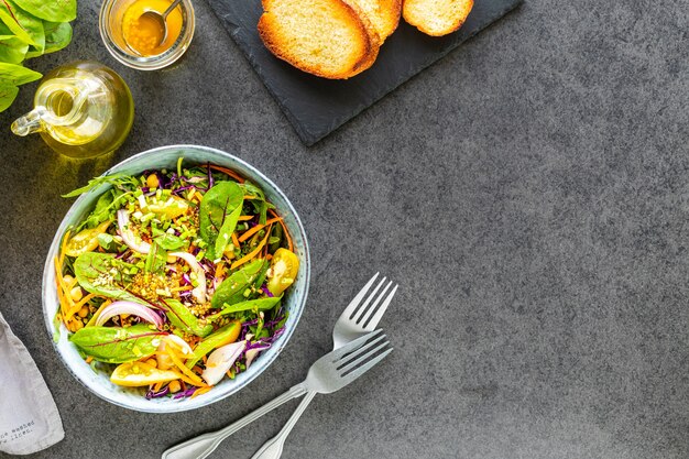 Fresh vegetable and fruit salad in a plate on black stone surface