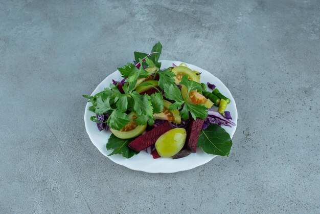 Fresh vegetable salad on white plate.