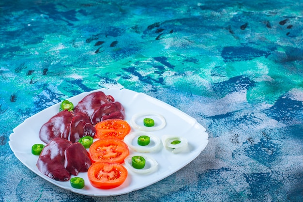 Fresh vegetables and chicken livers on a plate