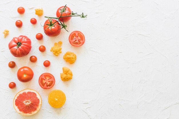 Fresh vegetables and citrus fruits on white backdrop
